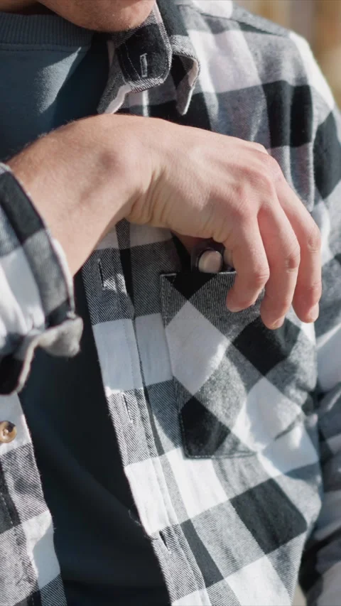 Close up man retrieving blister pack from checkered plaid fabric texture detail Stock Footage 345052188