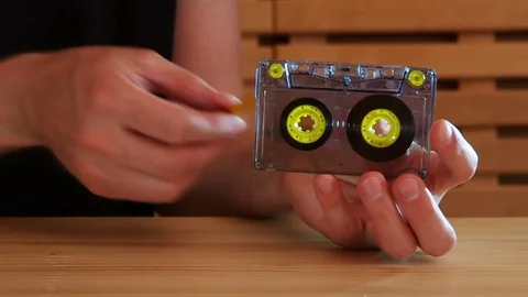 Close-up on a man rewinding compact cassette with a pencil and with studio light Stock Footage 77409454