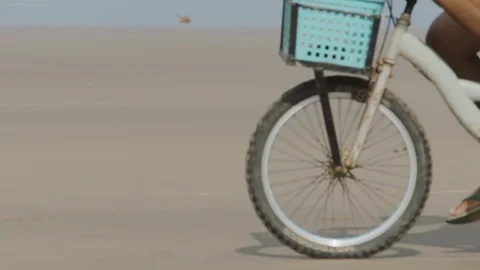 Close up of man riding bicycle on beach during day time Stock Footage 143017167