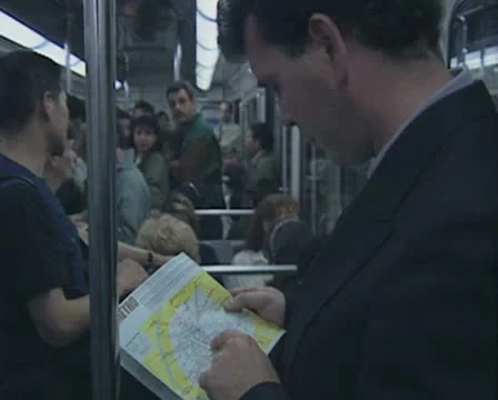 Close up of man riding subway train and looking at map Stock Footage 8916266
