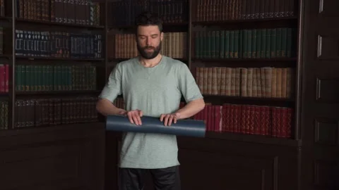 Close Up of Man Roll Out Yoga Mat For Fitness. Man Rolling  Out Blue Yoga Mat. Stock Footage 152567351