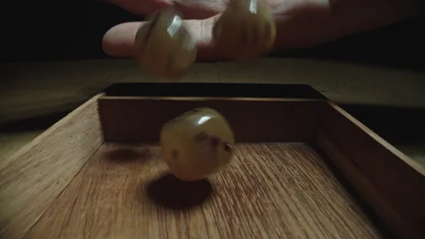 Close-Up of Man Rolling Translucent Dice in Game Tray Stock Footage 338017828