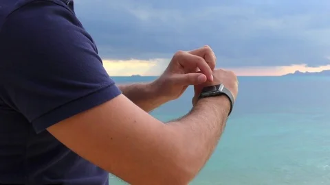 Close-up of a man 's hand with smart watch, uses a smart watch on the sea Stock Footage 81500184