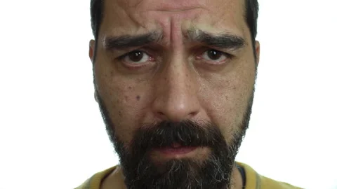 Close-up, a man with a sad face on a white background looks into the camera Stock Footage 142153084