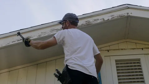 Close up of Man Scraping Old Paint of House Stock Footage 96878247