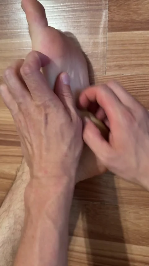 Close-up of man scratching his bare feet on wooden floor. Itching, irritation, Stock Footage 337404749
