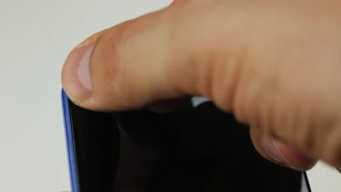 Close-up of a man sealing the front camera of a smartphone with an insulating Stock Footage 158546436