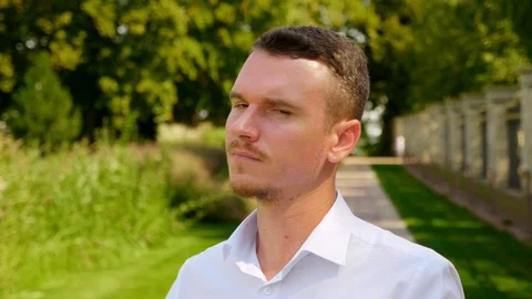 Close up man with a serious look turns and looks at the camera Stock Footage 129958046