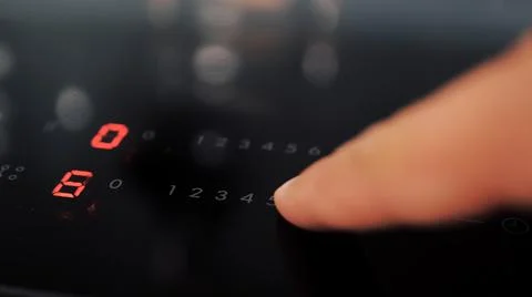 Close up of man setting temperature control on hob Stock Photos