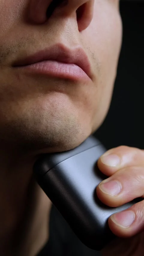 Close up man shaving face with compact electric shaver, personal grooming and Stock Footage 318065757
