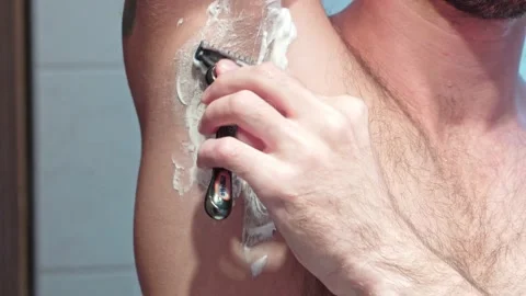 Close-up of a man shaving his armpit hair with a machine with blades. Shave the Stock Footage 219094888