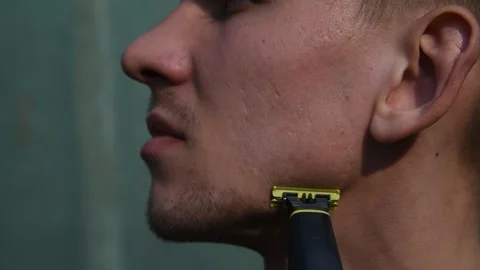 Close-up of a man shaving his beard on his face with a Black razor. Stock Footage 131143774