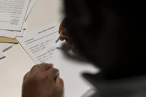Close up of a man signing work contract with human resources manager Stock Photos