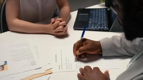 Close up of a man signing work contract with human resources manager Stock Photos