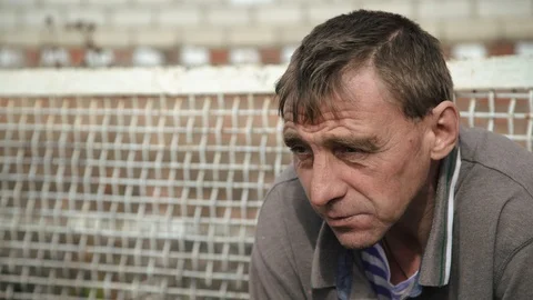 Close up. A man sits in the yard of his farm and smokes Stock Footage 105212551
