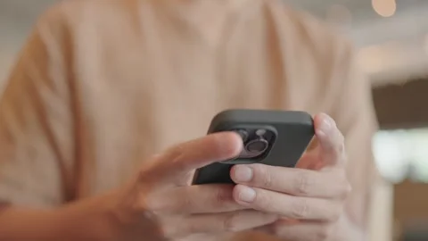 Close-up of a man sitting and typing a message on his smartphone in the network  Stock Footage 251974246