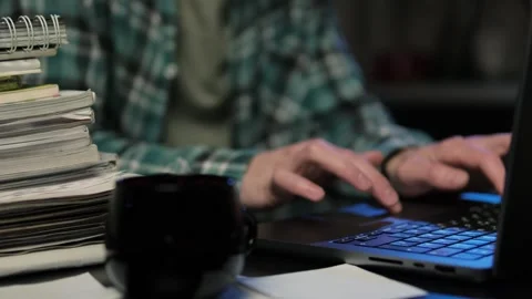Close-up of a man sitting at a kitchen table at night, using a laptop for remote 스톡 동영상 297188094