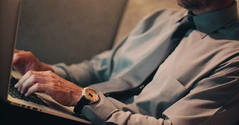 Close up of man sitting on sofa and typing on laptop Stock Footage 61448134