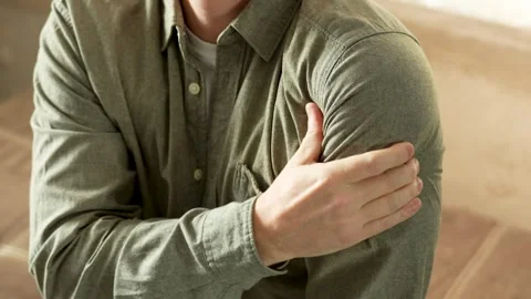 Close-up of man sitting on sofa doing massage on shoulder with hand Stock Footage 270729584