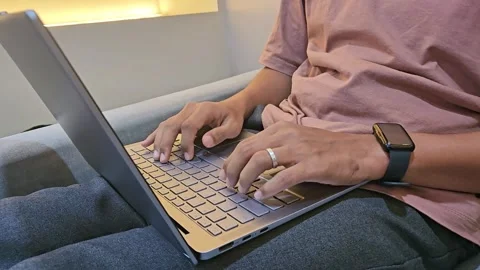 Close Up man sitting on sofa using laptop. Work from home Stock Footage 288943997