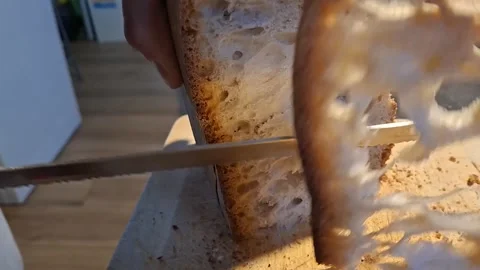 Close Up of Man Slicing Crunchy Rustic Italian Bread with Large Air Holes Stock Footage 334686156