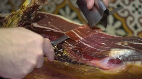 Close-up of man slicing Iberian ham at a shop in Granada, Spain. 库存影片 55735795