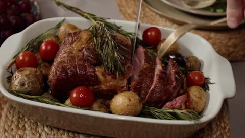Close-Up of Man Slicing Roasted Pork with Vegetables for Holiday Dinner Stock Footage 340339846