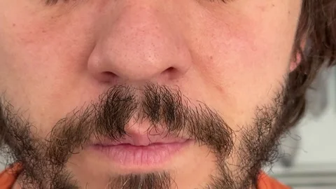 Close-up of a man slightly sniffling, nose tensing in a natural facial gesture Stock Footage 336524319