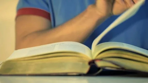 Close up of a man slowly turns over the golden pages of an book in slow motion. Stock Footage 84270996