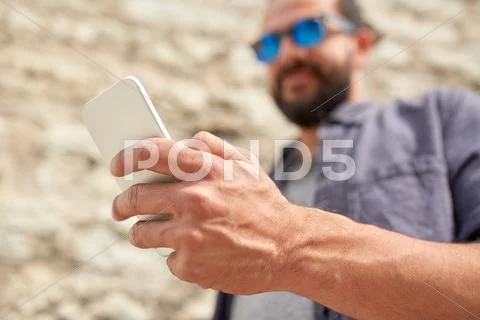 Close up of man with smartphone at stone wall Stock Photos