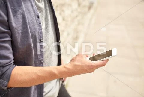 Close up of man with smartphone at stone wall Stock Photos