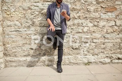 Close up of man with smartphone at stone wall Stock Photos