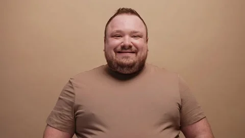Close-up of a man smiling at camera on a beige background Vídeo Stock 237548921