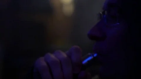 Close-up of a man smoking an electronic cigarette at night. Stock Footage 78588300