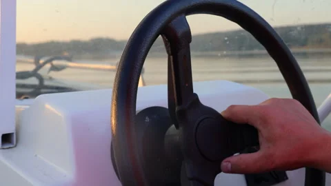 Close-up of a man spinning the steering wheel of a boat Stock-Footage 283489370