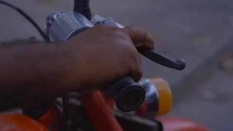 Close-up of a man squeezes the clutch on the handlebars of a motorcycle Stock-Footage 107536994