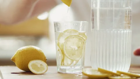 Close Up of Man Squeezing Fresh Lemon Slice into Glass of Water 4K 10-bit	 Stock Footage 332678928
