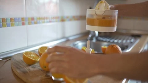 Close of Man Squeezing Oranges Using Electric Squeezer. Stock Footage 127249188