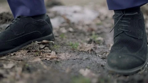 Close-up, man steps over a puddle in the forest. black shoes Stock Footage 195219377