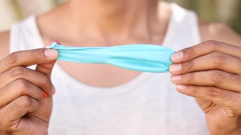 Close-up of Man Stretching a Light Blue Latex Balloon Stock Footage 264897894