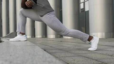 Close-up of man stretching thighs and hamstrings to decrease chance of injury 库存影片 83968417