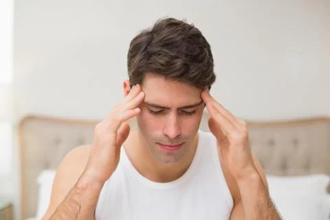 Close up of a man suffering from headache in bed Stock Photos