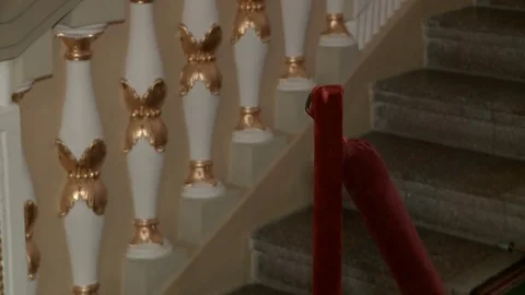 Close-up of a man in a suit descends the steps and cleans the fence with a red Stock Footage 77203311