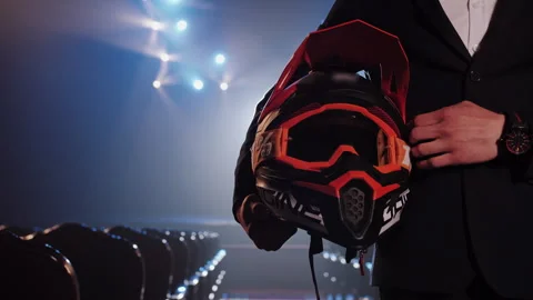 Close Up of Man in Suit Holding Bright Motocross Helmet with Goggles Video stock 336193594
