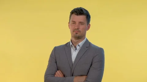 Close-up of man in suit putting his finger to the temple on yellow background. Stock Footage 120834587