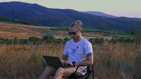 Close Up of Man in Sunglasses Typing on Laptop in Nature Vídeos de archivo 345717377