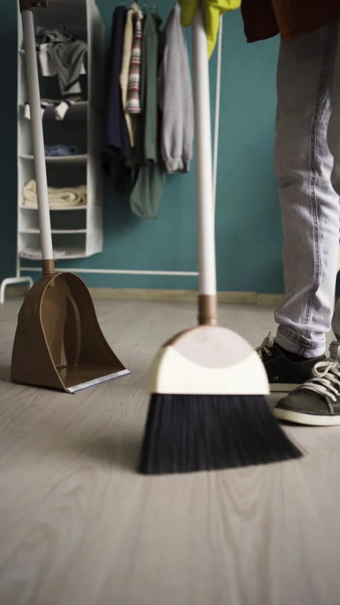 Close-up of man sweeping floor with plastic broom. Cleaning and housework 動画素材 308656100
