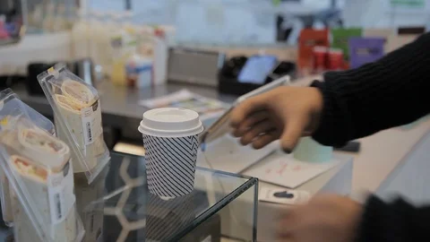 Close up of man taking cup of coffee by robot bionic hand in the shop program Stock Footage 94408292