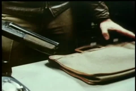 Close-up man taking gun out of bag and putting it down on desk Stock Footage 11346427
