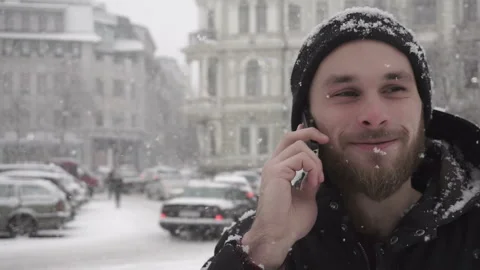 Close-up of a man talking on cellphone outdoors on winter day. Young male have a Stock Footage 85570331